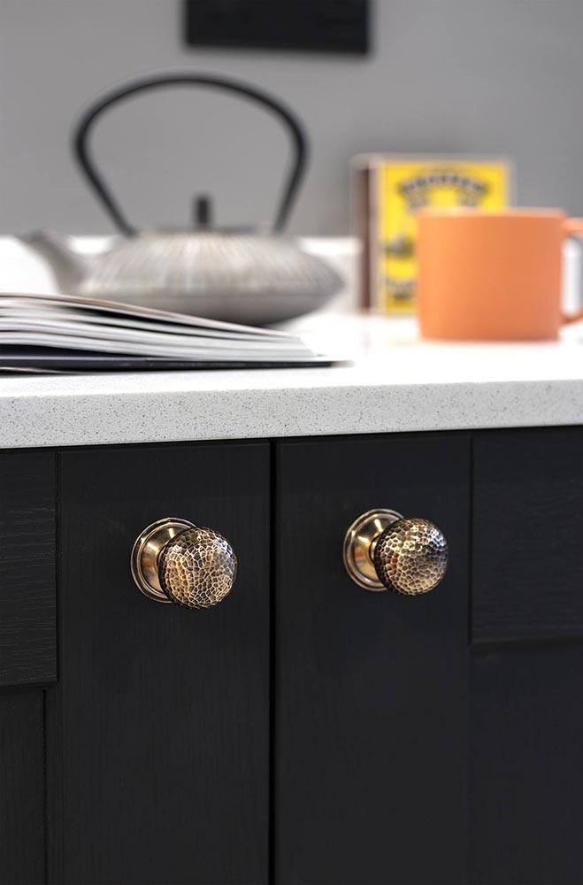 From The Anvil Hammered Mushroom Cupboard Knob in Polished Bronze on a Dark Blue kitchen with white countertop