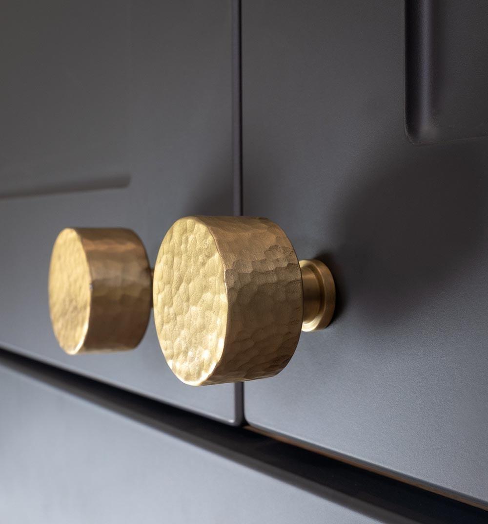 Alexander and Wilks Leila Cupboard Knob in Satin Brass on a grey Cabinet at More Handles.