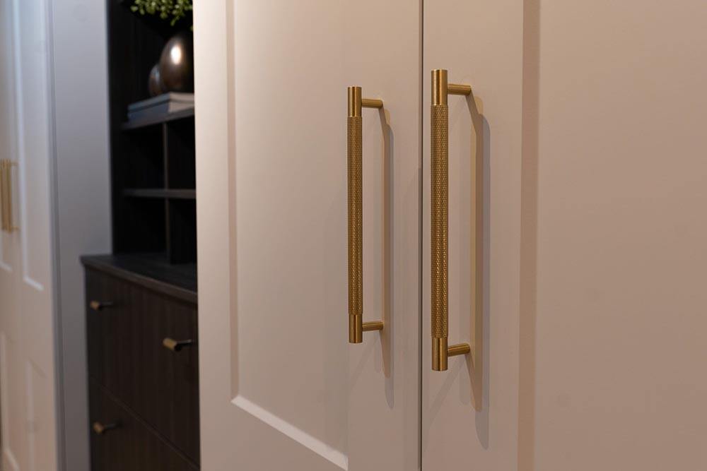 Satin Brass Alexander and Wilks Brunel Knurled Cupboard Handle on Off-Whte Wardrobe at More Handles